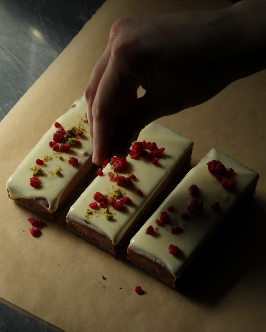 Topping white chocolate bars with freeze-dried raspberries